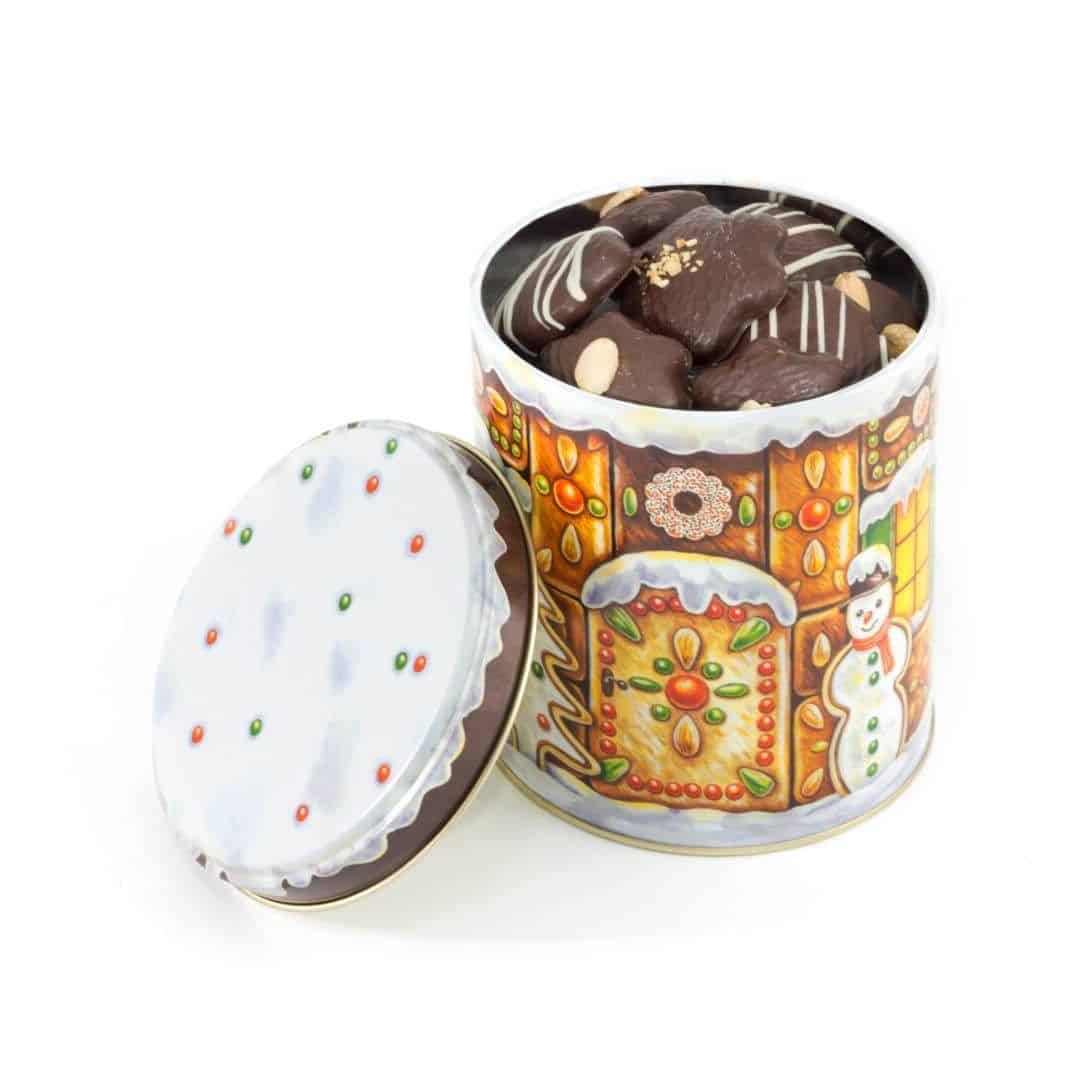 Puszka „Piernikowy domek” Puszka z dekorowanymi piernikami w czekoladzie deserowej oraz ciasteczkami orzechowymi.